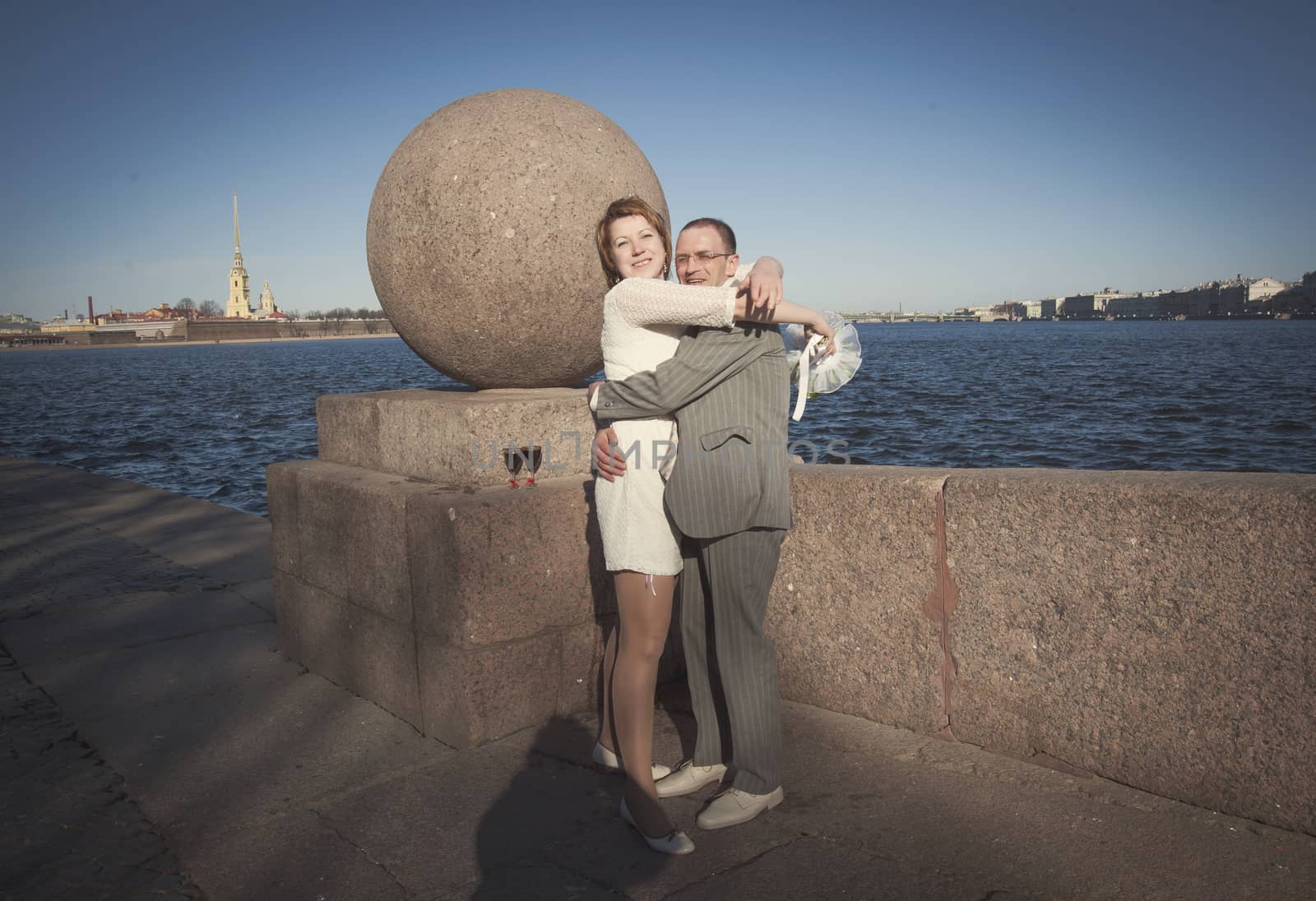 couple walk along the embankment of the river