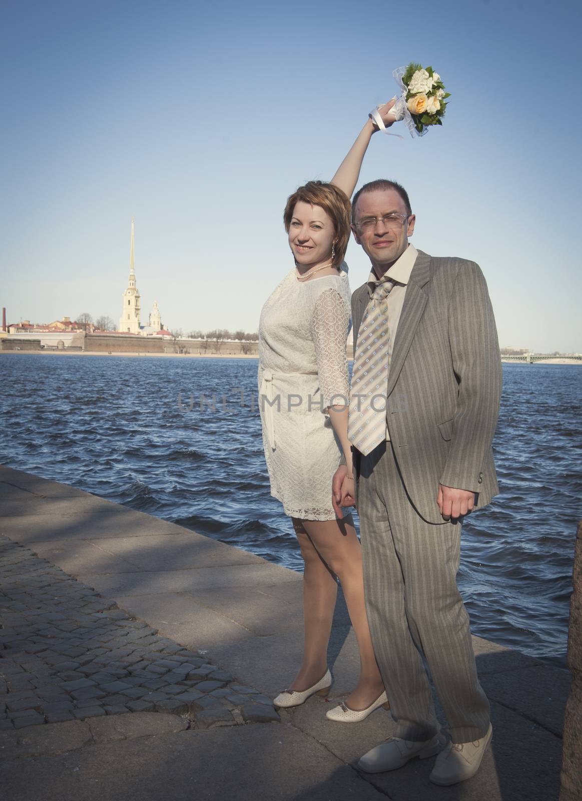 couple walk along the embankment of the river