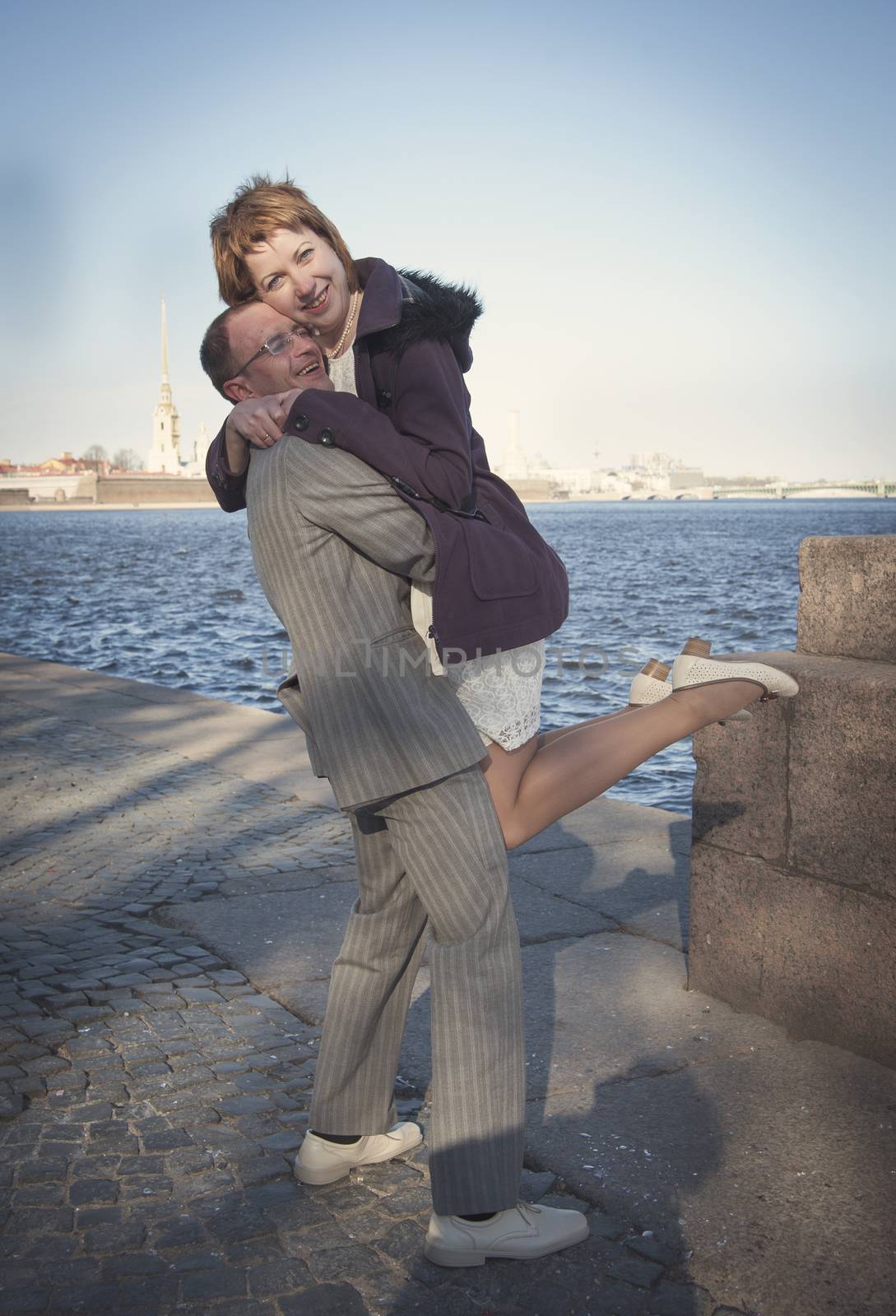 couple walk along the embankment of the river