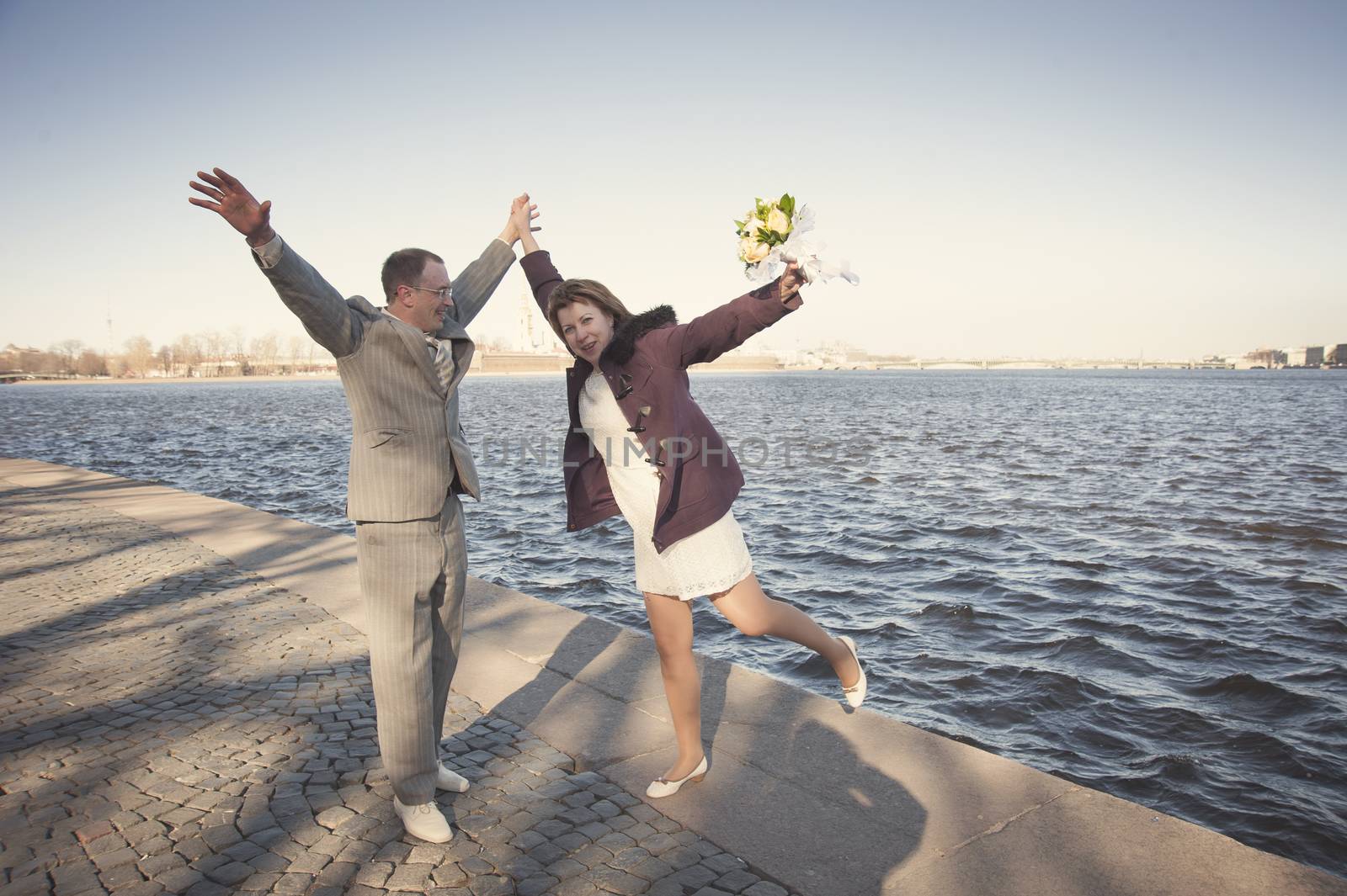 couple walk along the embankment of the river