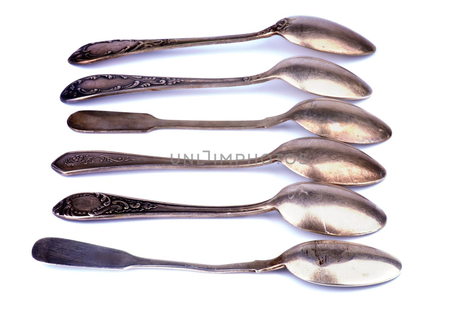 Arrangement of Old Silver Spoons In a Row isolated on white background