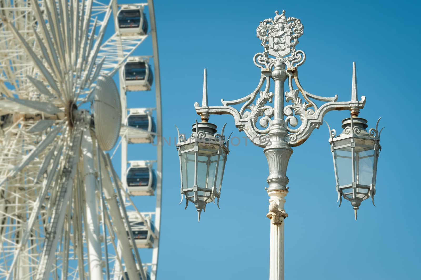 decorative victorian street lamp with ferris wheel in the background