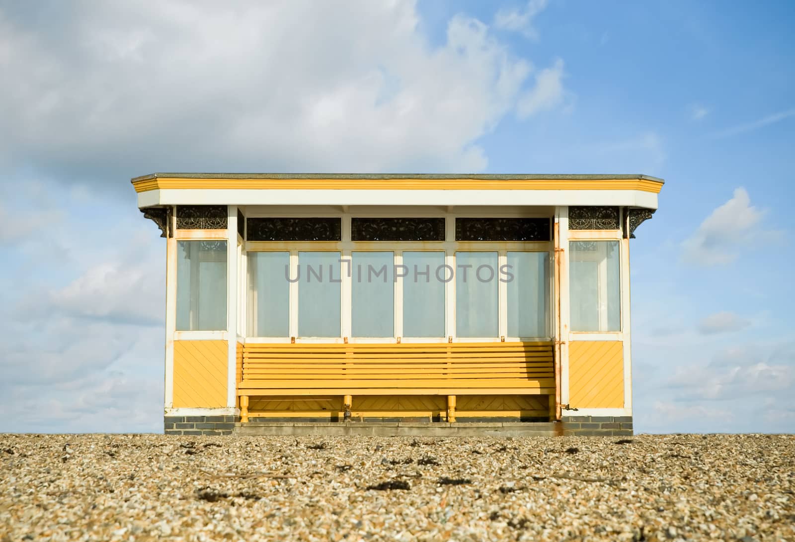 weathered beach storm shelter against a blue cloudy sky