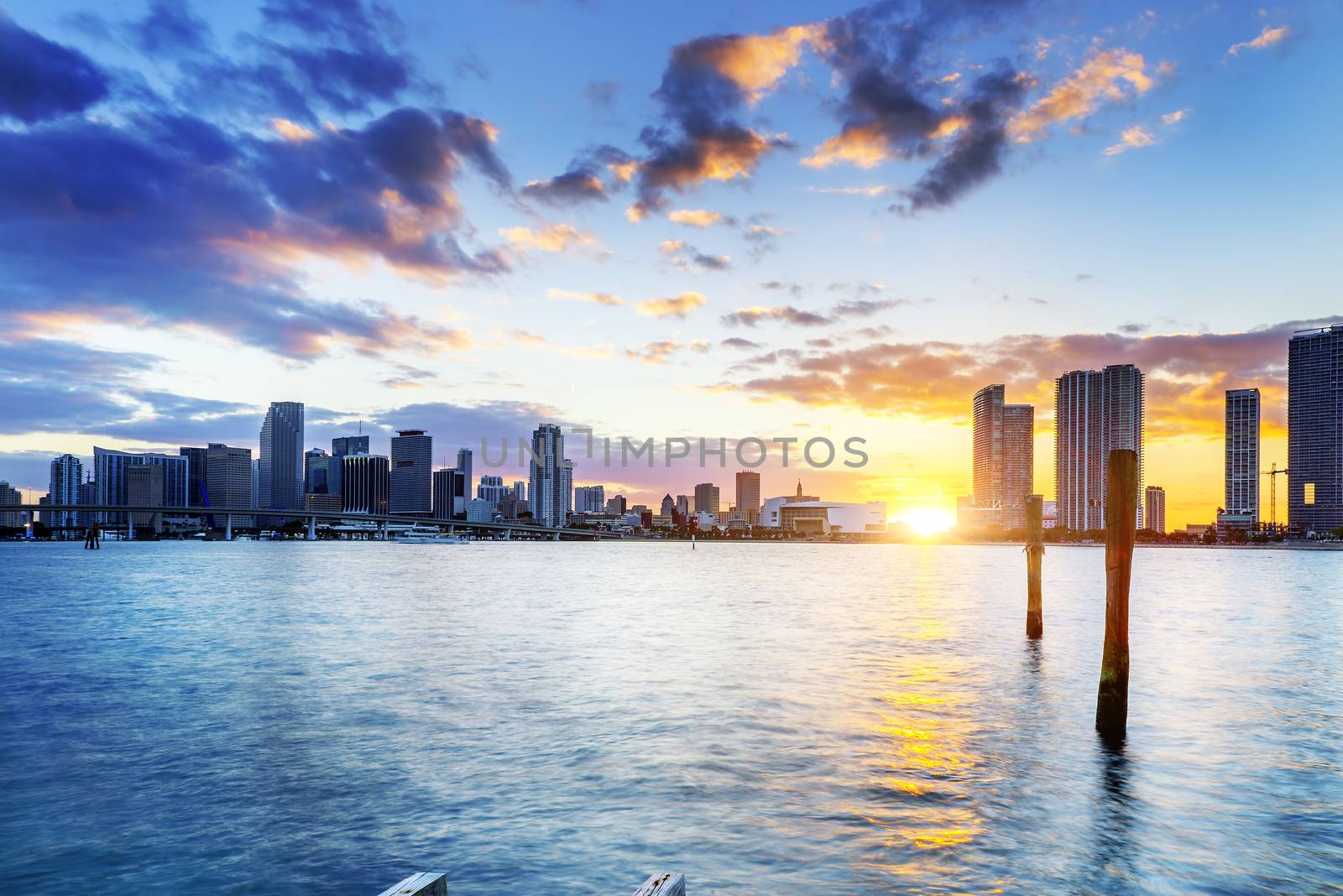 Miami city skyline panorama at dusk with urban skyscrapers over sea with reflection 