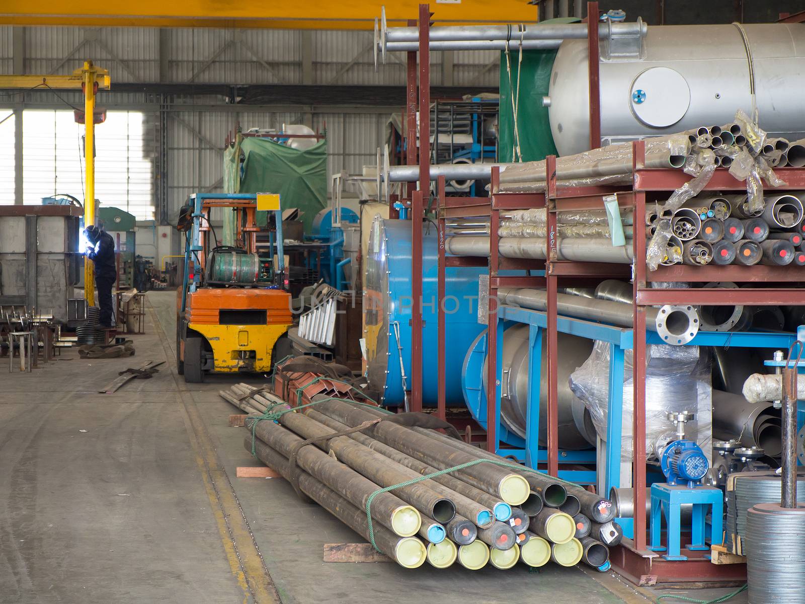 Interior of mechanical workshop at factory with welder in the background.