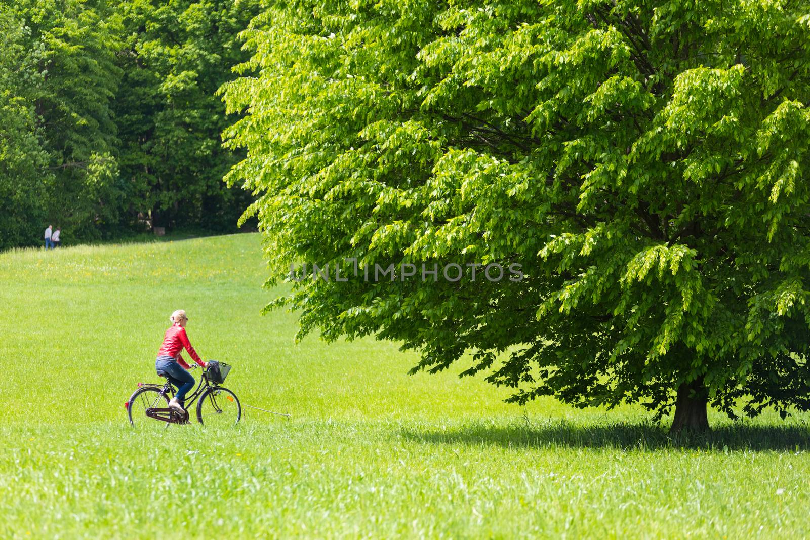 Happy young woman riding a bicycle. in the park.