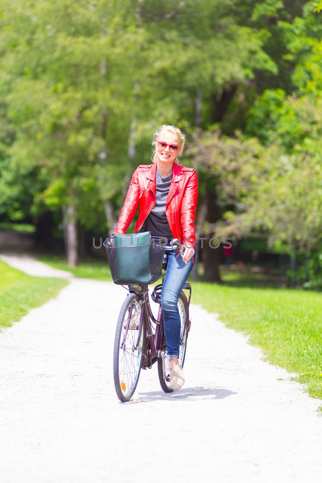 Happy young woman riding a bicycle. in the park.