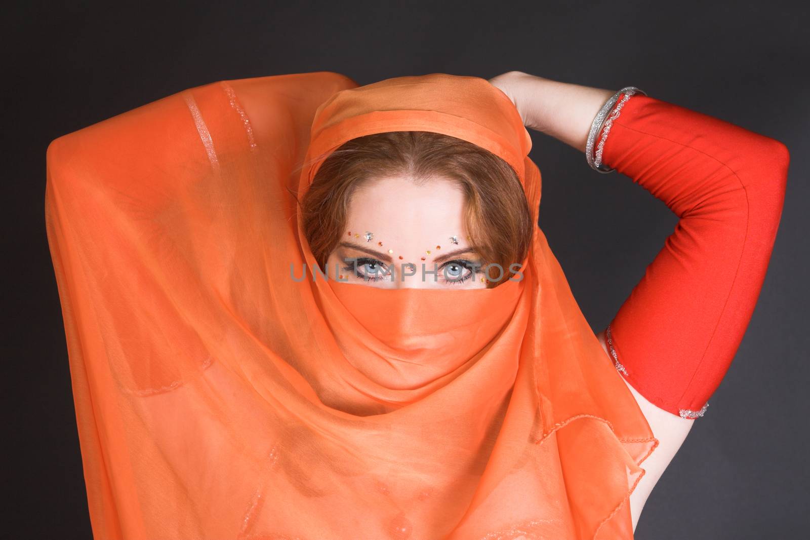 Blue eyed belly dancer with a brightly colored scarf