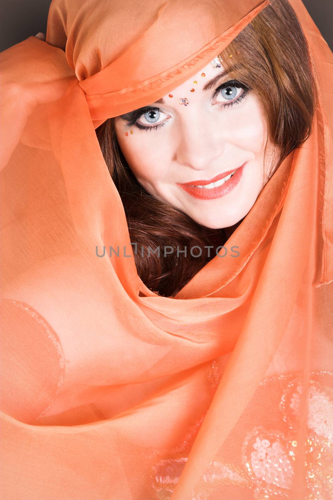 Blue eyed belly dancer with a brightly colored scarf