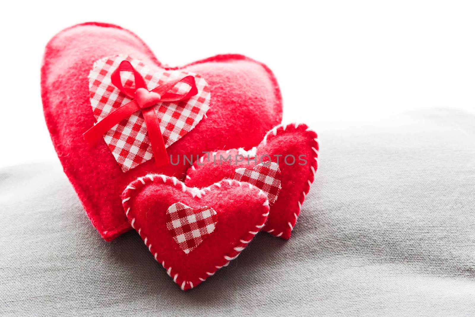 Handmade plush red hearts on the soft pillow. Romantic love by photocreo