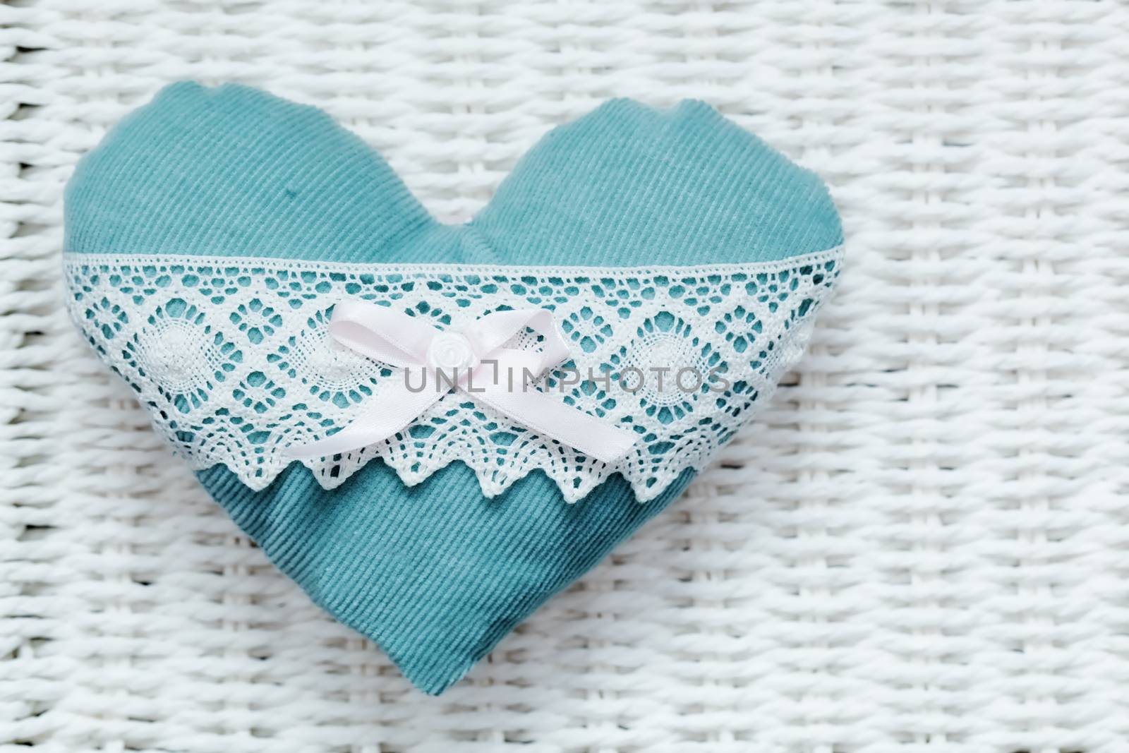 Vintage handmade plush turquoise heart on white rustic wicker. Romantic love, Valentine's Day concepts.