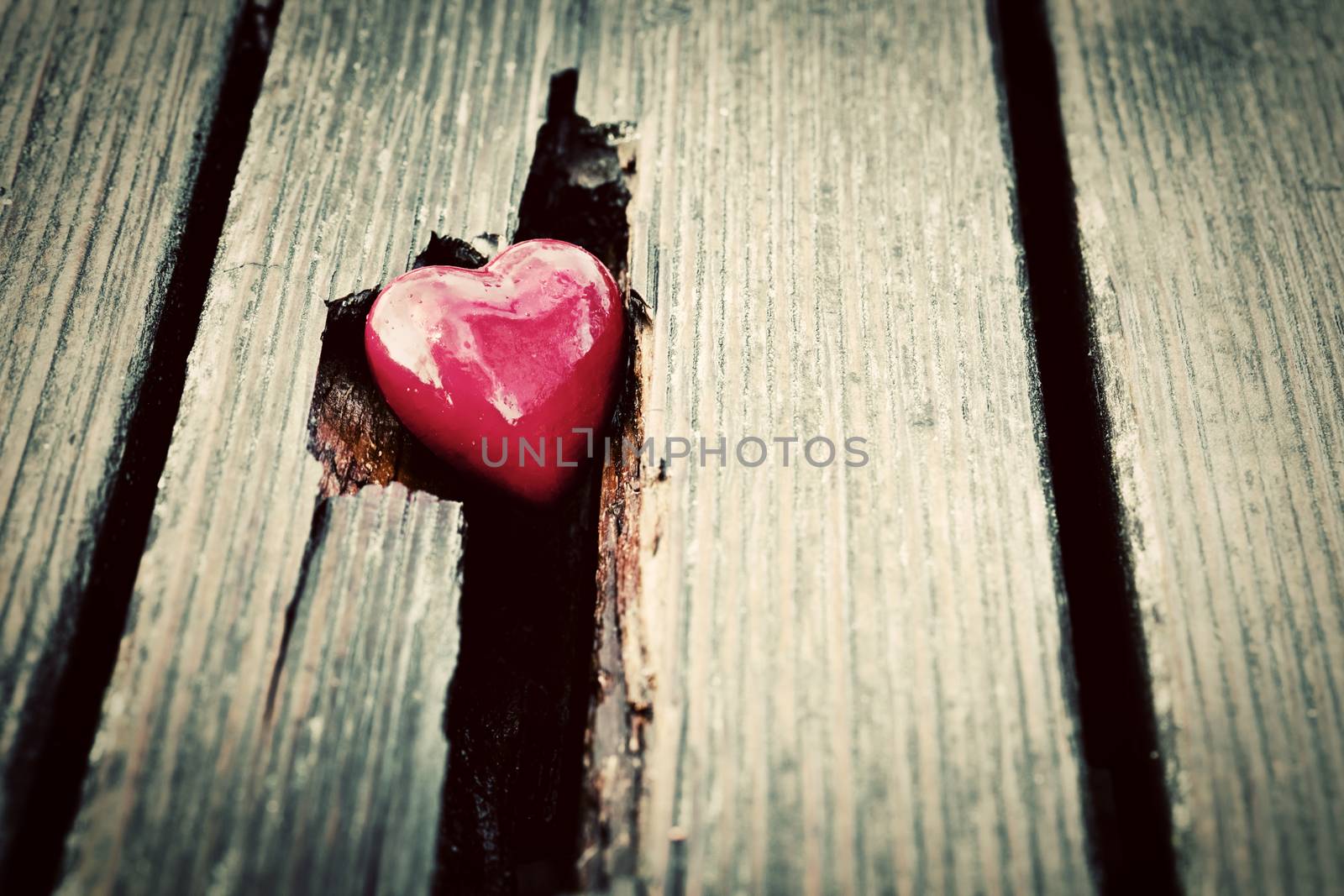 Red heart in crack of wooden plank. Symbol of love, Valentine's Day. Vintage style