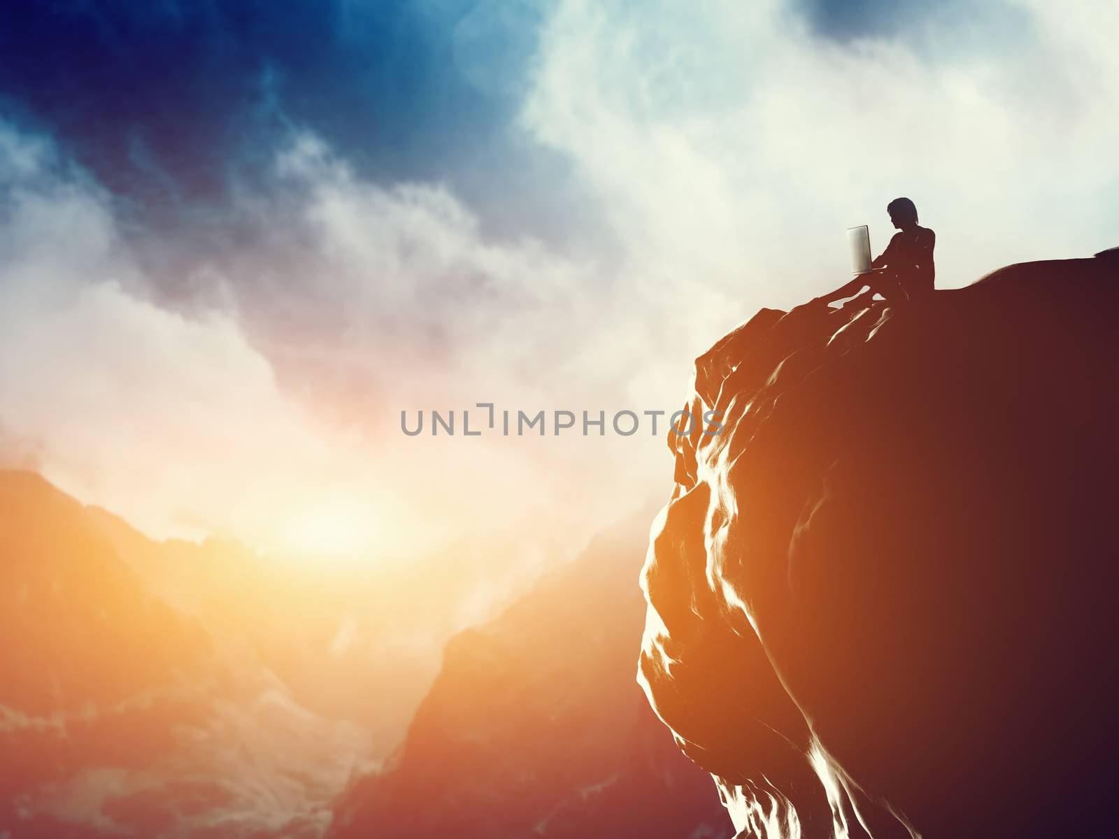 A man working on laptop sitting on the peak of a mountain at sunset. by photocreo