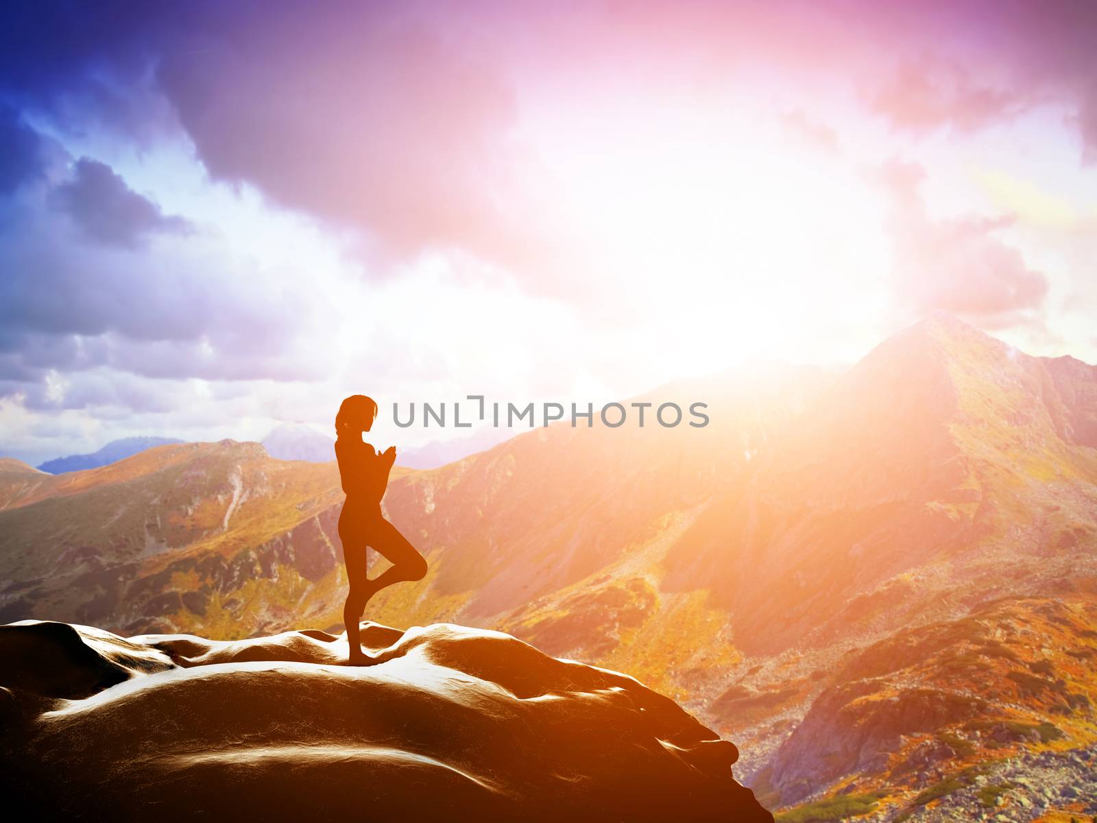 Woman standing in tree yoga position, meditating on rock in mountains at sunset. Zen, meditation, peace
