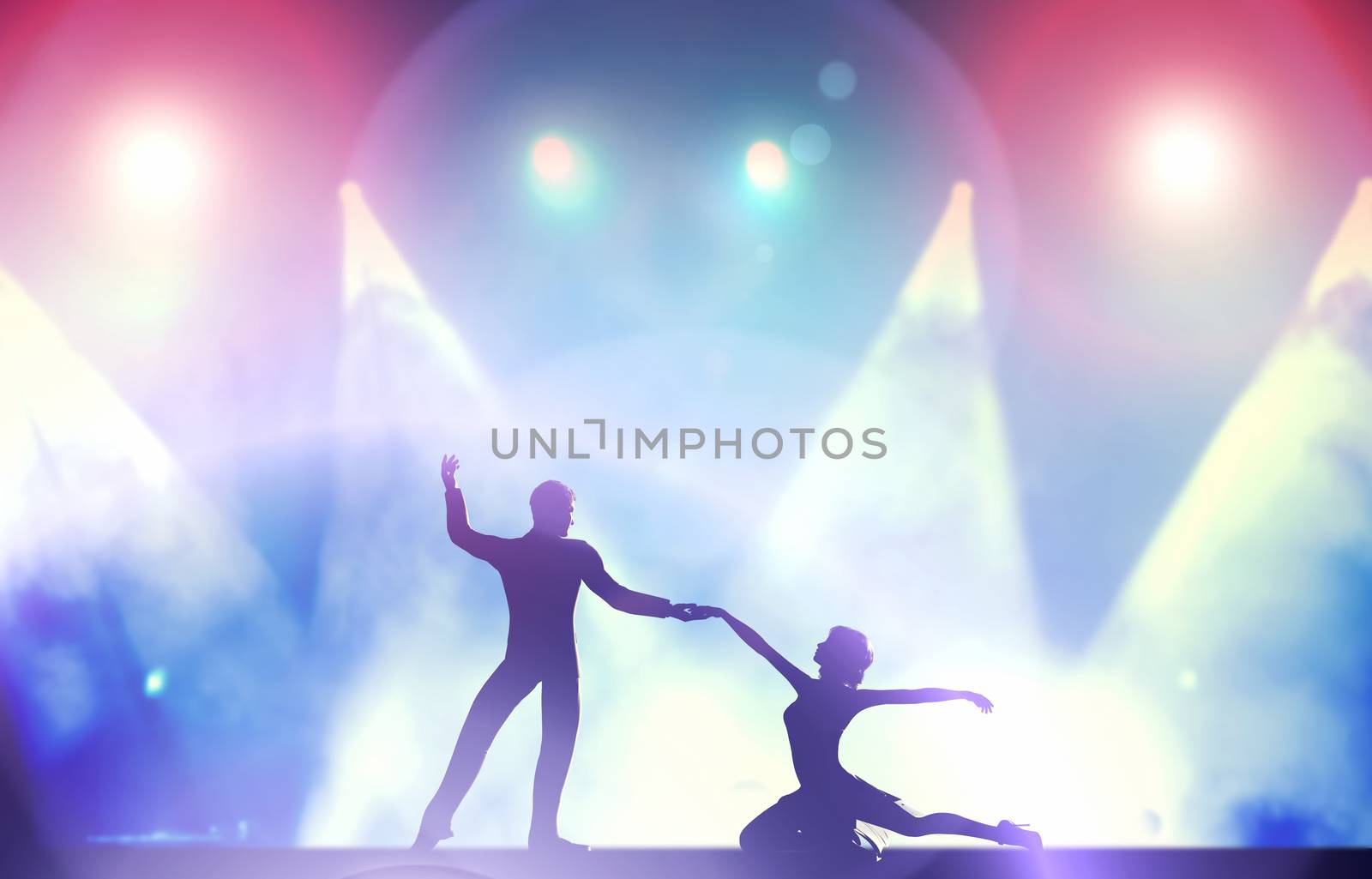 A couple of dancers in elegant, passionate dancing pose in club lights by photocreo