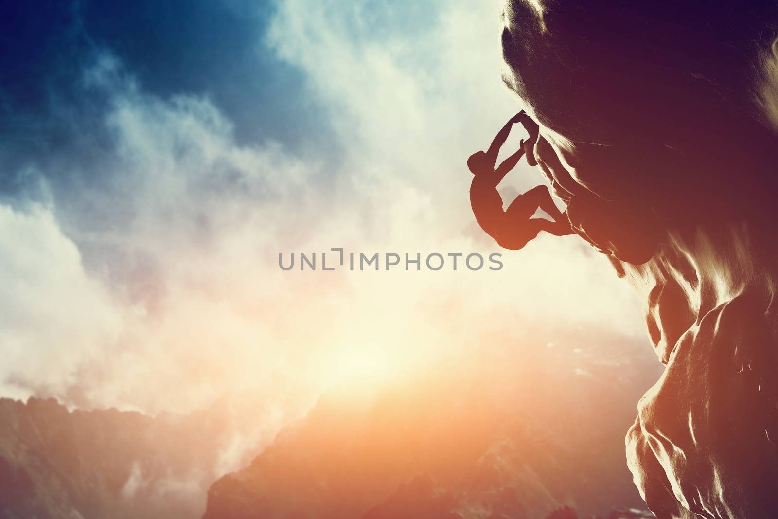 A silhouette of man climbing on rock, mountain at sunset.  by photocreo