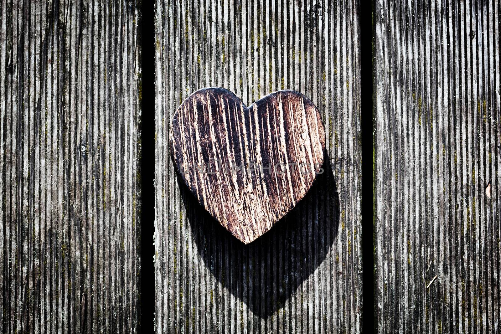 A wooden vintage heart on grunge wood planks. Symbol of love, by photocreo