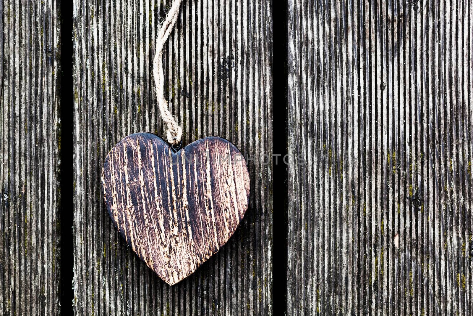 A wooden vintage heart on grunge wood planks. Symbol of love, by photocreo