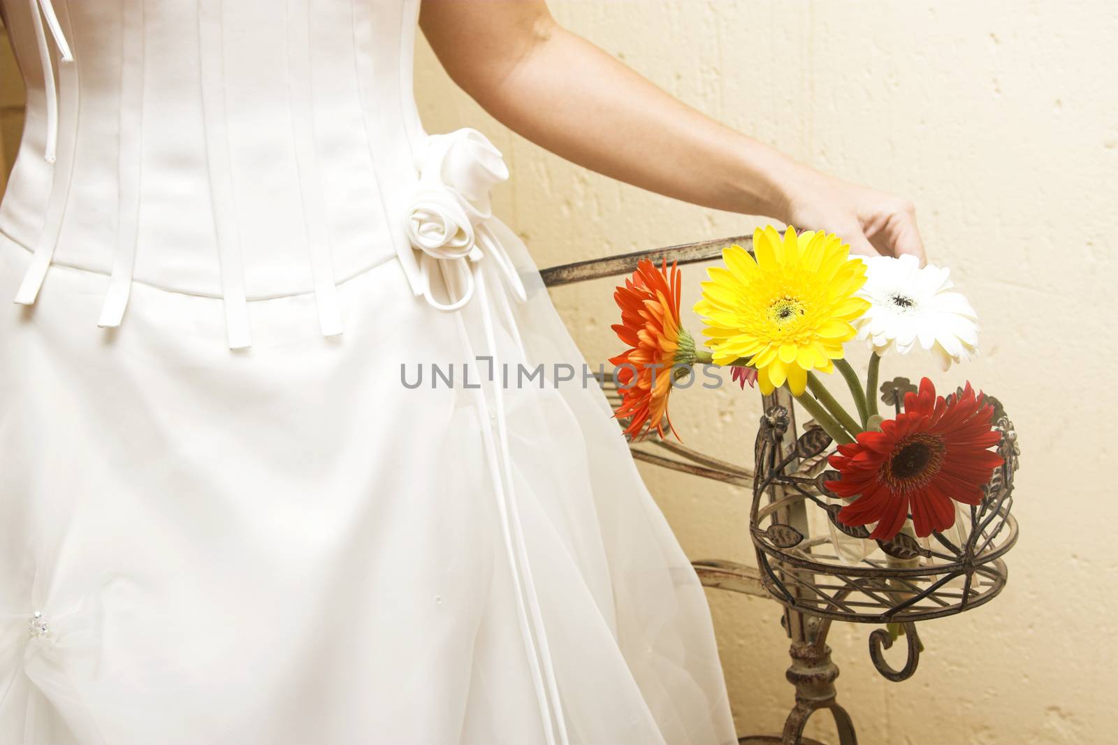 Bride standing next to daisy flower arrangement