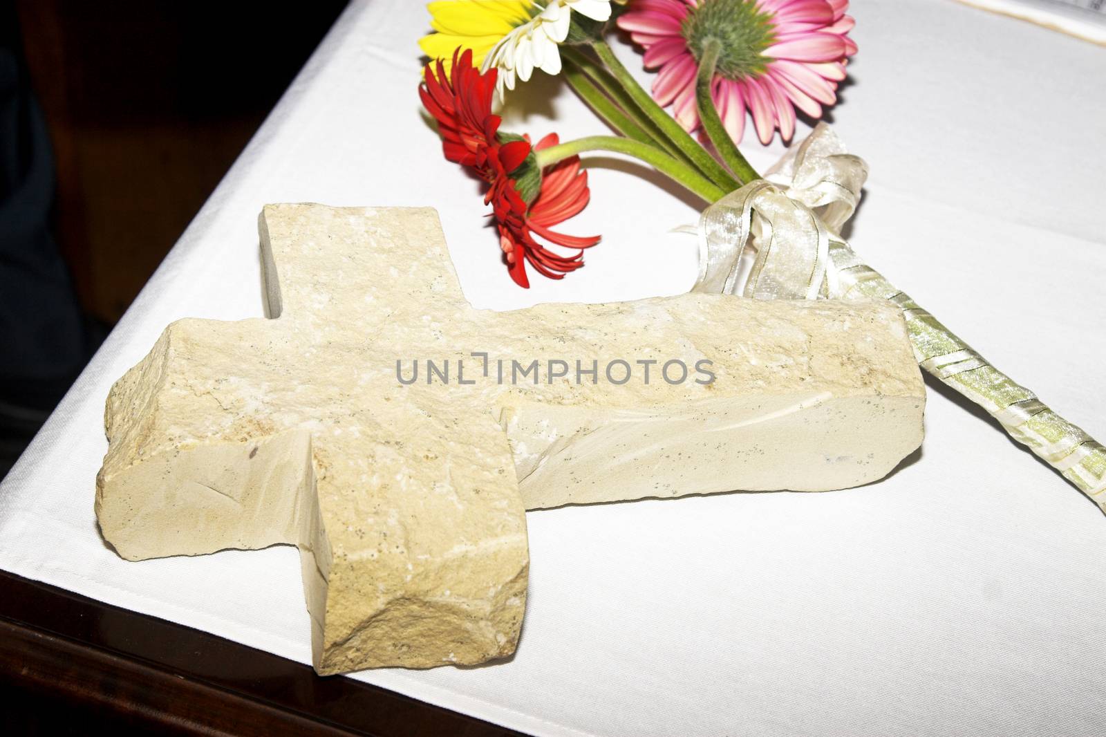 Daisy flowers and ceramic cross on table at wedding