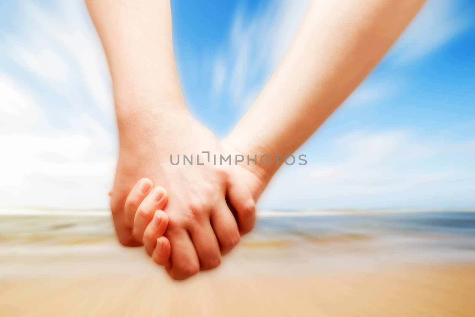 A couple in love hand in hand on the sunny beach. Vacation, romance, happiness