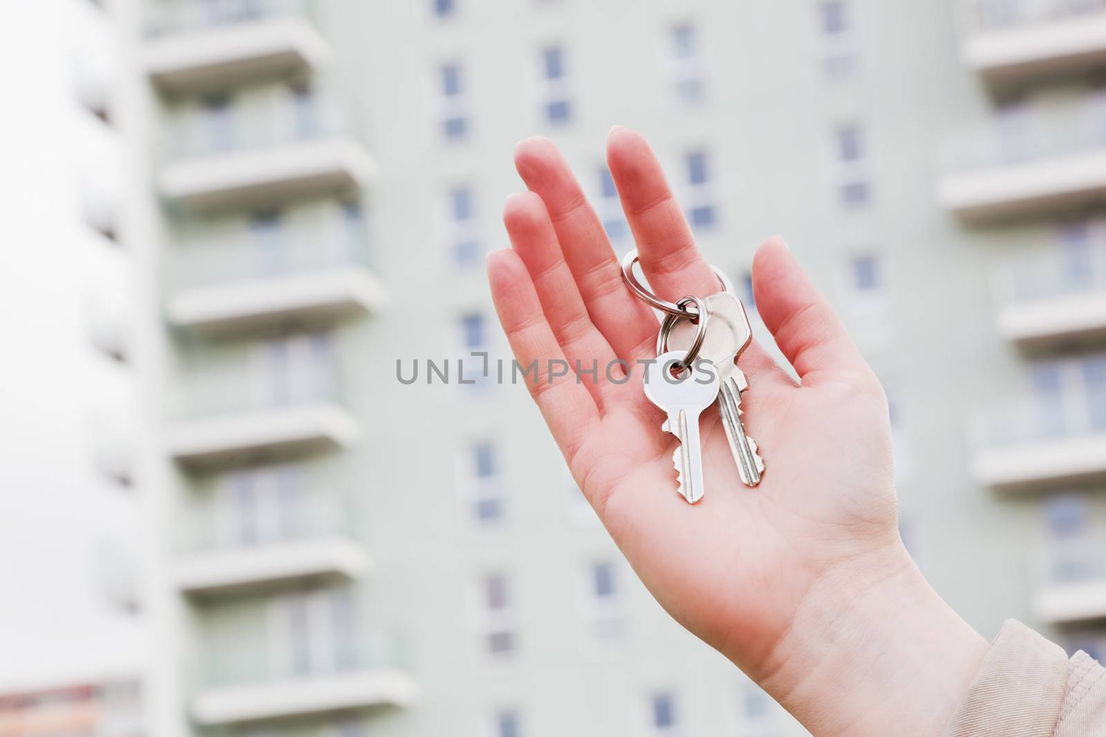 A real estate agent holding keys to a new apartment in her hands. Real estate industry