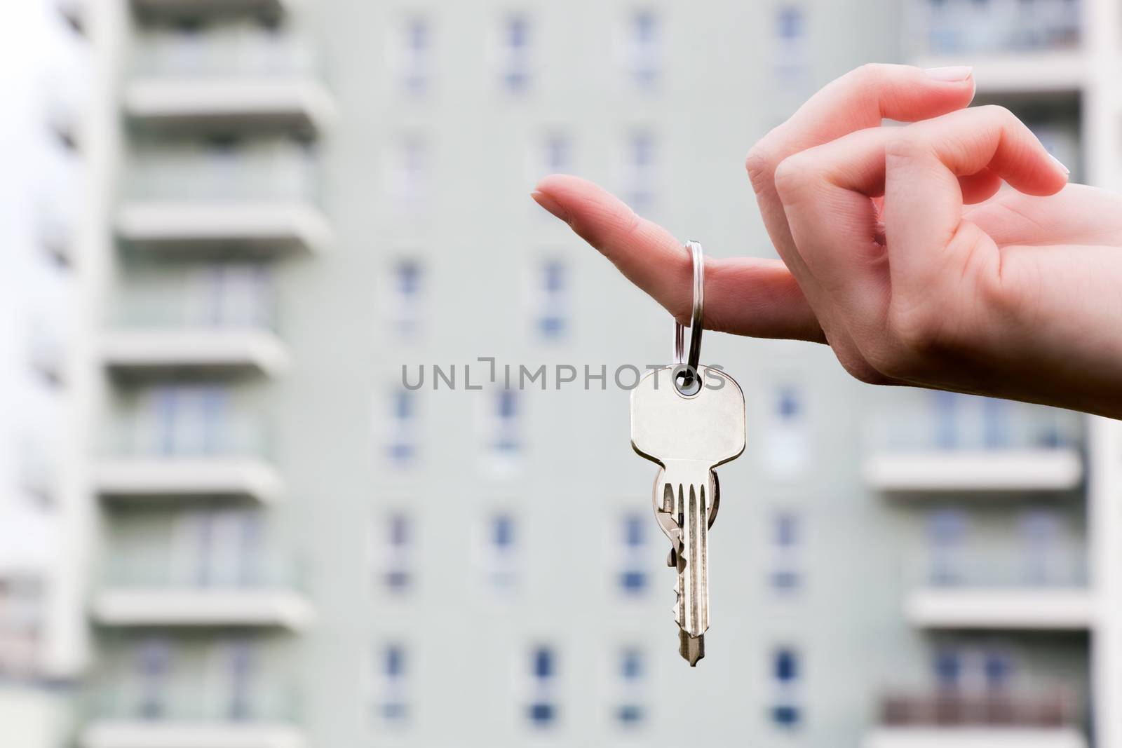A real estate agent holding keys to a new apartment in her hands. by photocreo