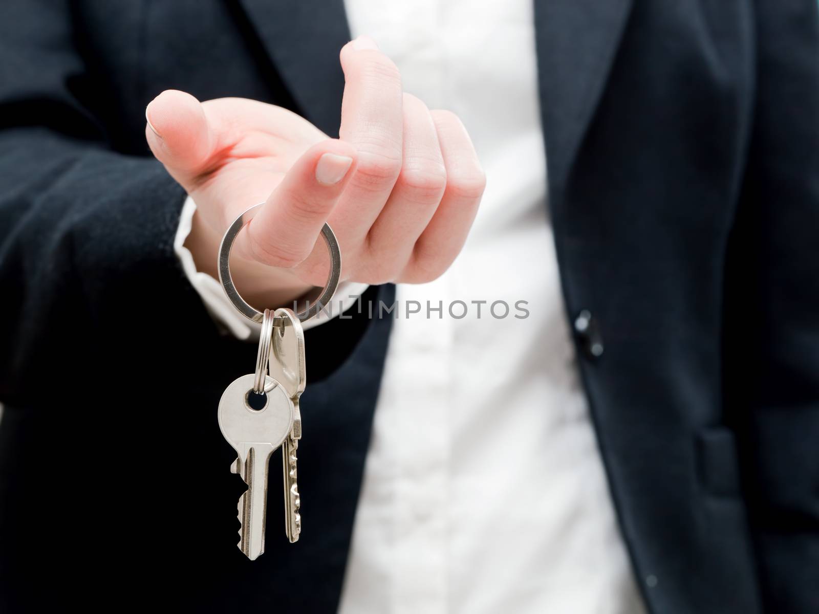 A real estate agent holding keys to a new house in her hands. Real estate industry