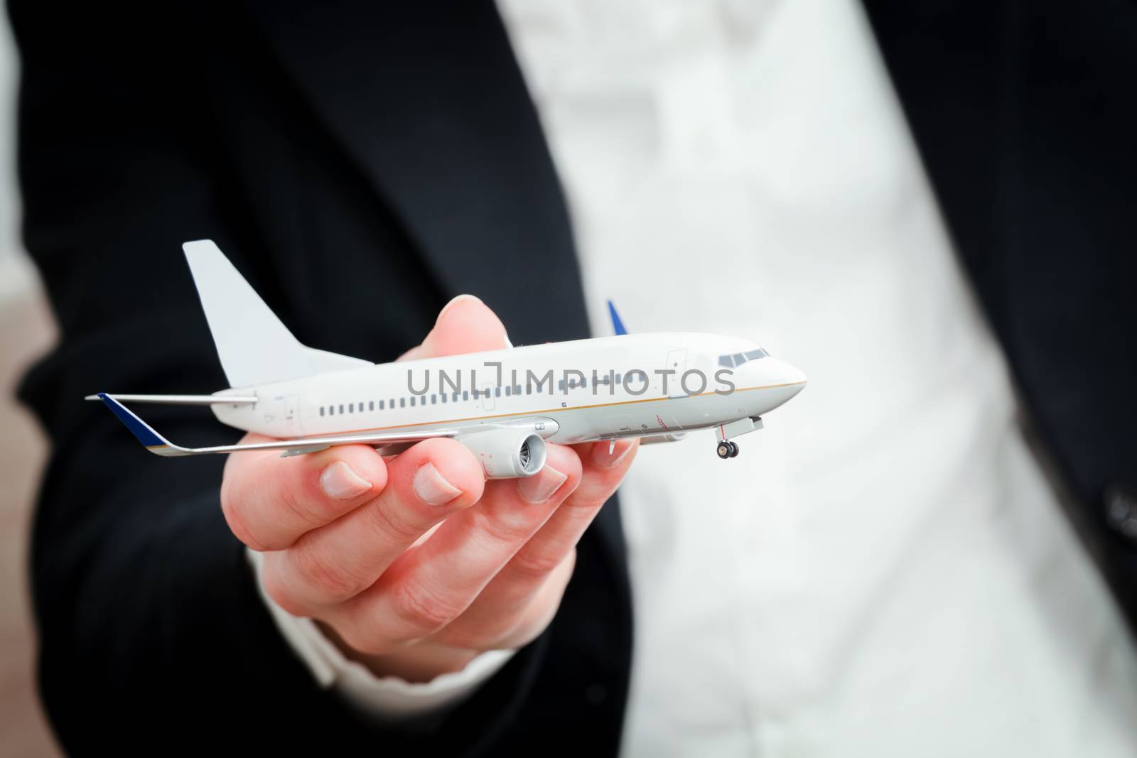 A business person holding an airplane model in hand. Concepts of aerial transport, aircraft industry, airline company.
