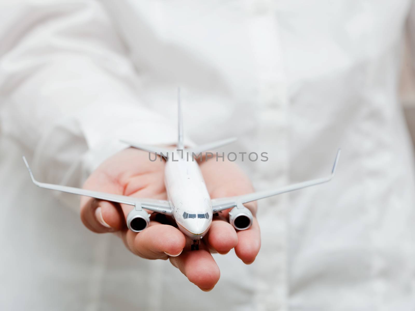 A business person holding an airplane model in hand. Concepts of aerial transport, aircraft industry, airline company.