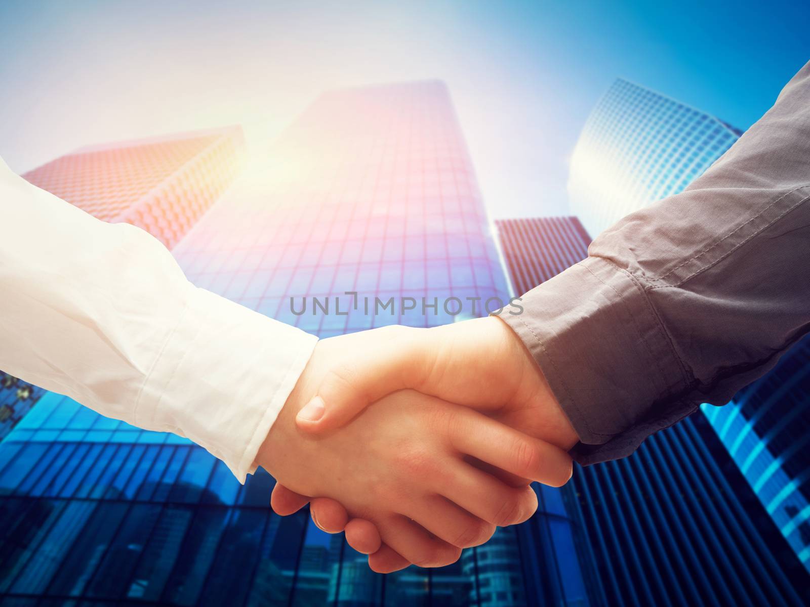 Business handshake on modern skyscrapers background. Deal, success, contract, cooperation concepts 