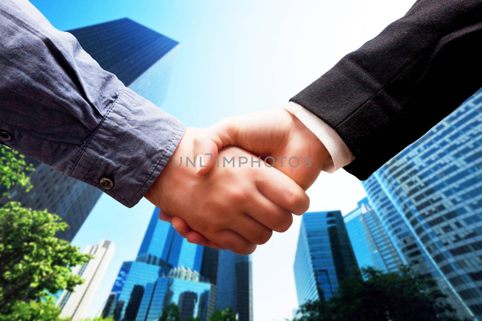 Business handshake on modern skyscrapers background. Deal, success, contract, cooperation concepts 