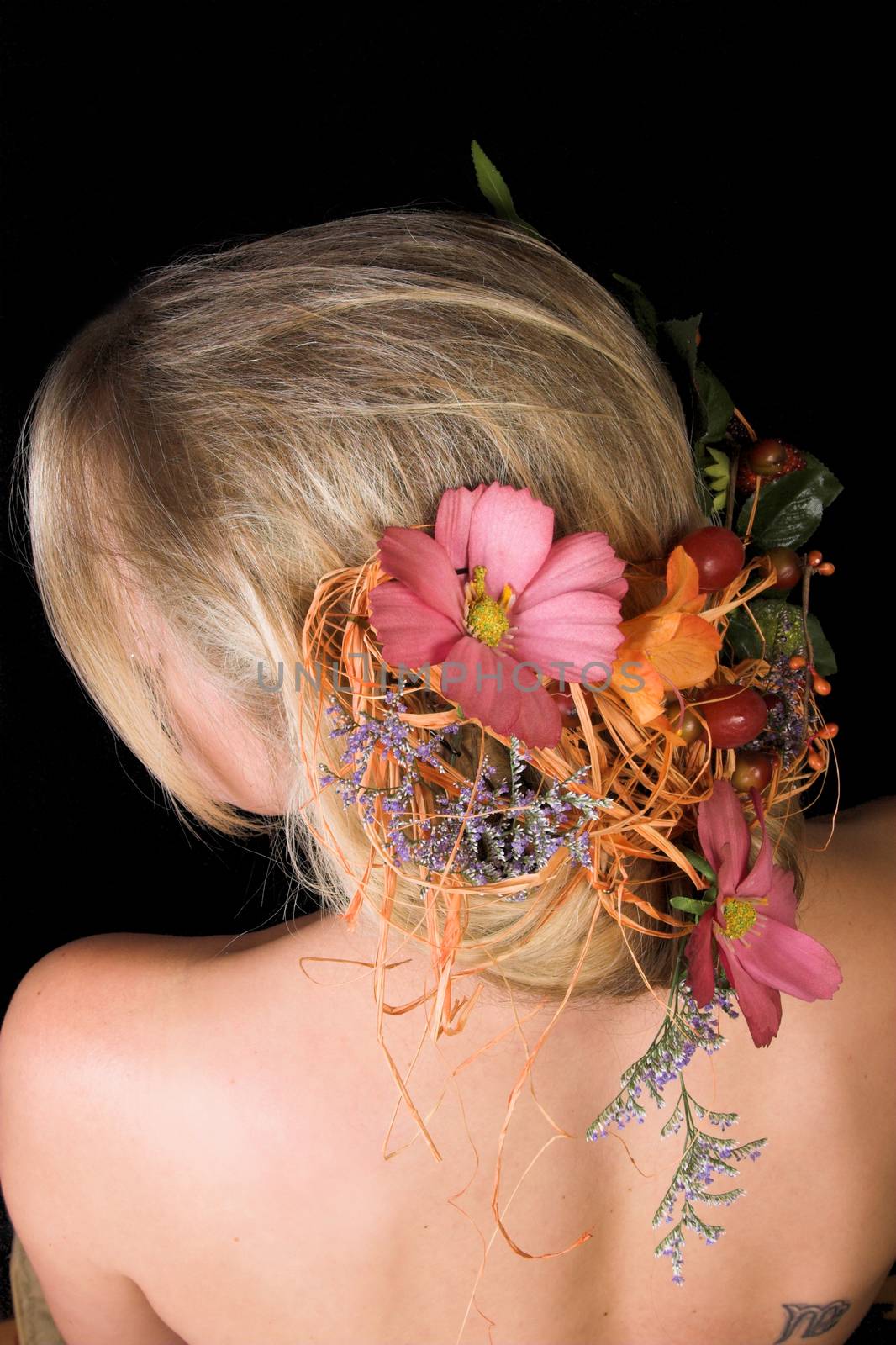Beautiful young blond model with flowers in her hair