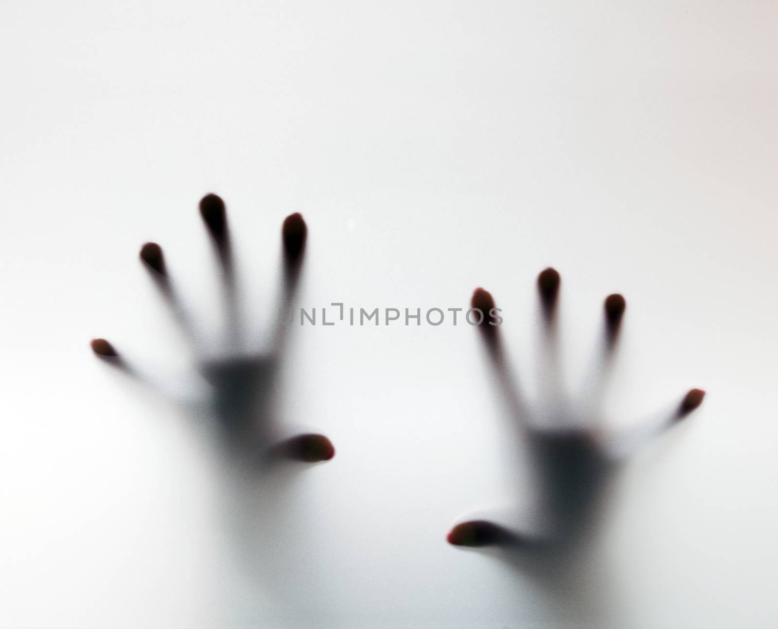 Hands touching frosted glass. Conceptual scream for help by photocreo