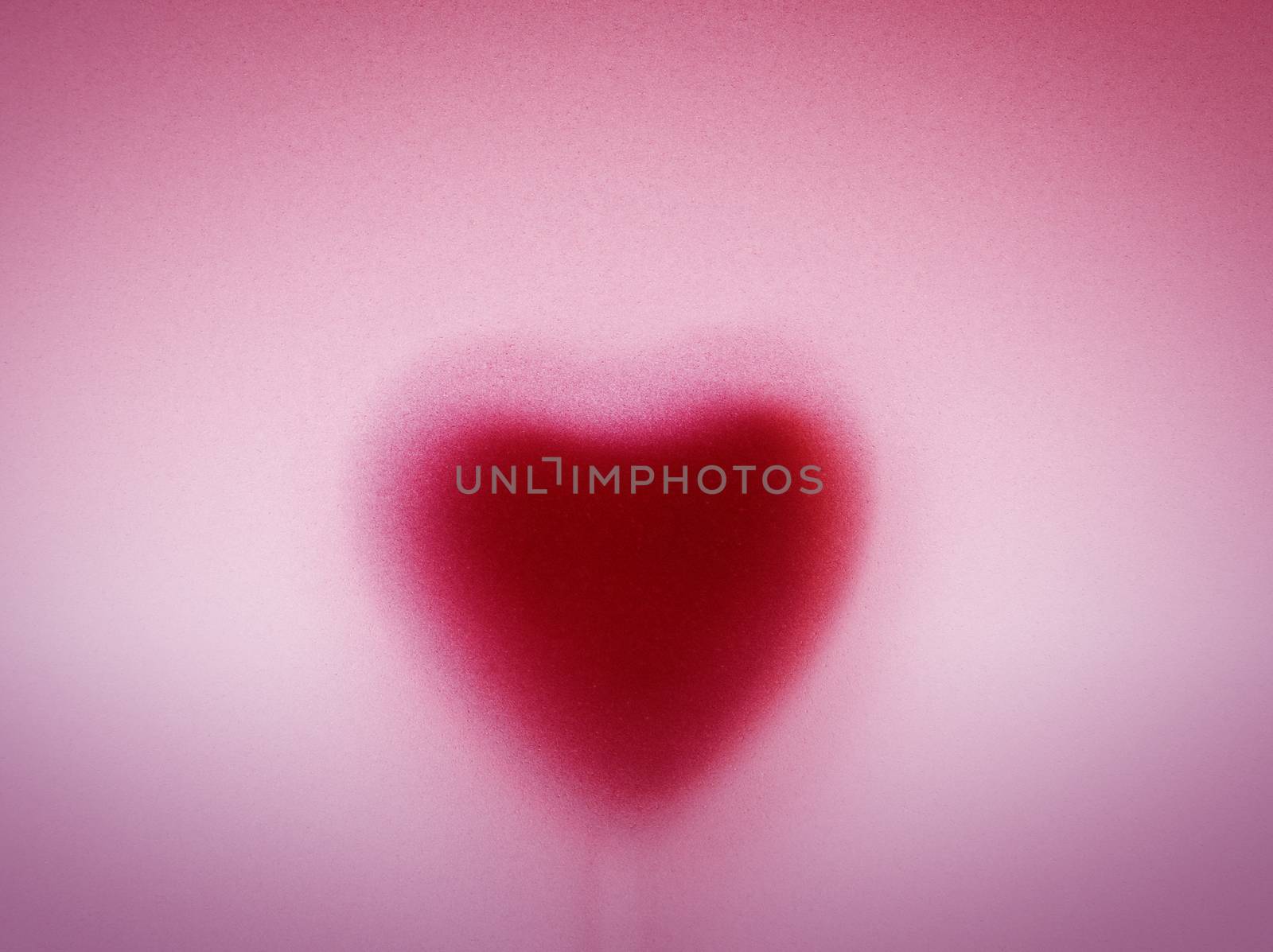Heart shape behind milky frosted glass. Love, romantic pink background. Vintage passion for Valentine's Day.