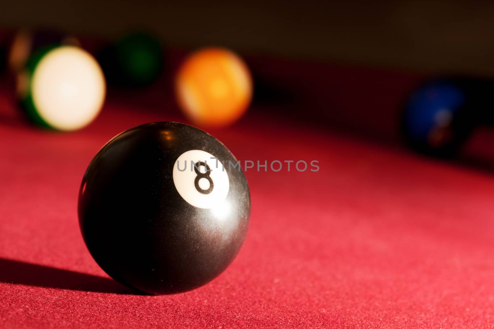 Billards pool or snooker game. The black eight ball. Red cloth table