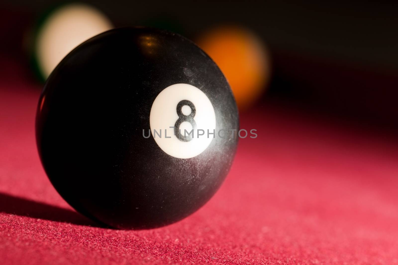 Billards pool or snooker game. The black eight ball. Red cloth table