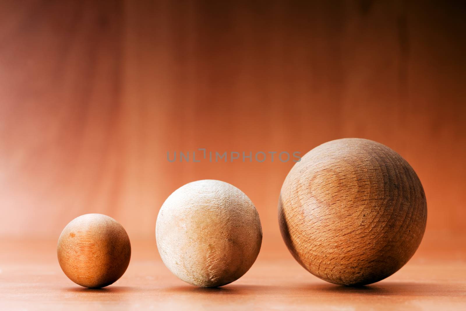 Three wooden balls on a wooden board. by photocreo