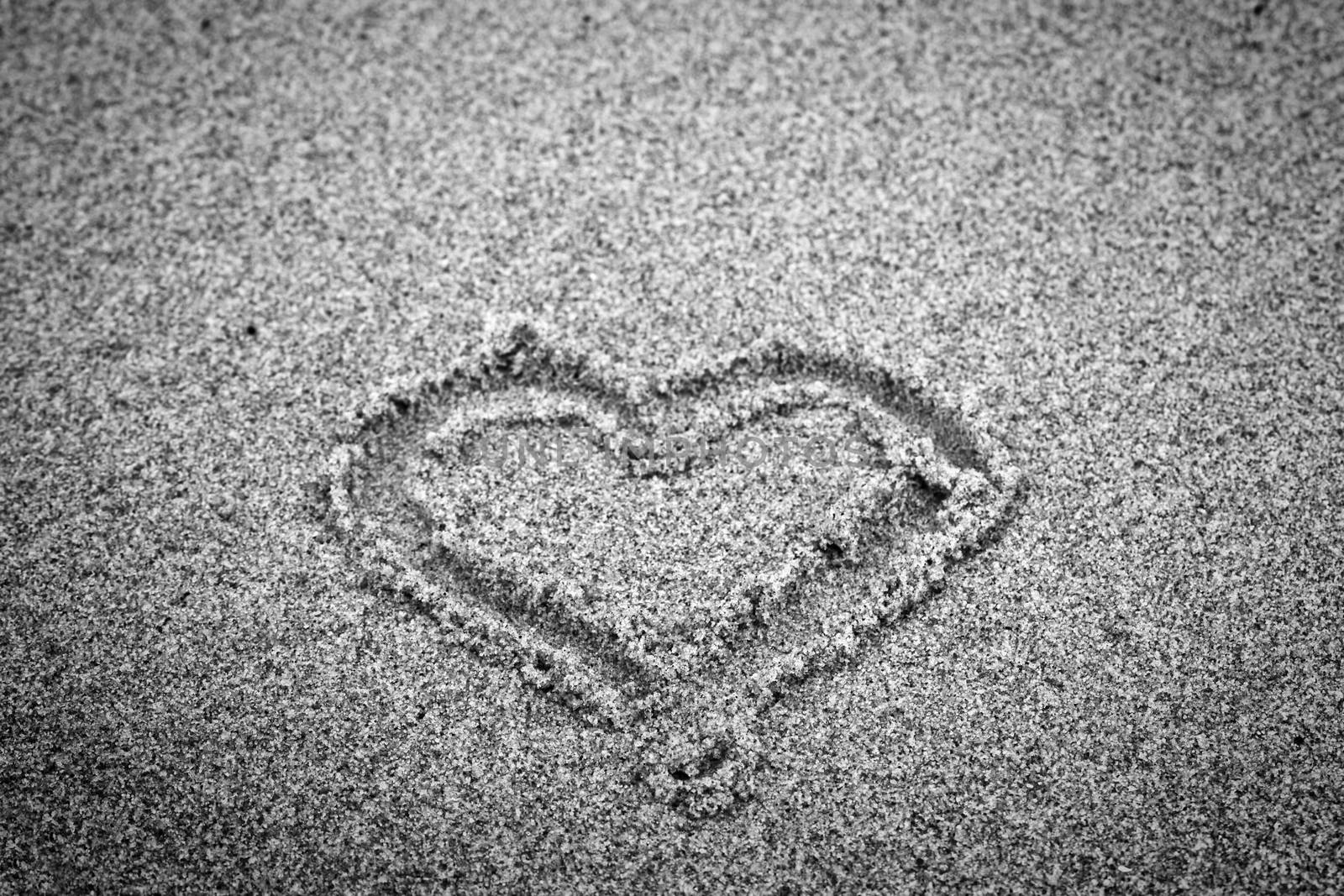 Heart shape on sand. Romantic, black and white, hand drawn.
