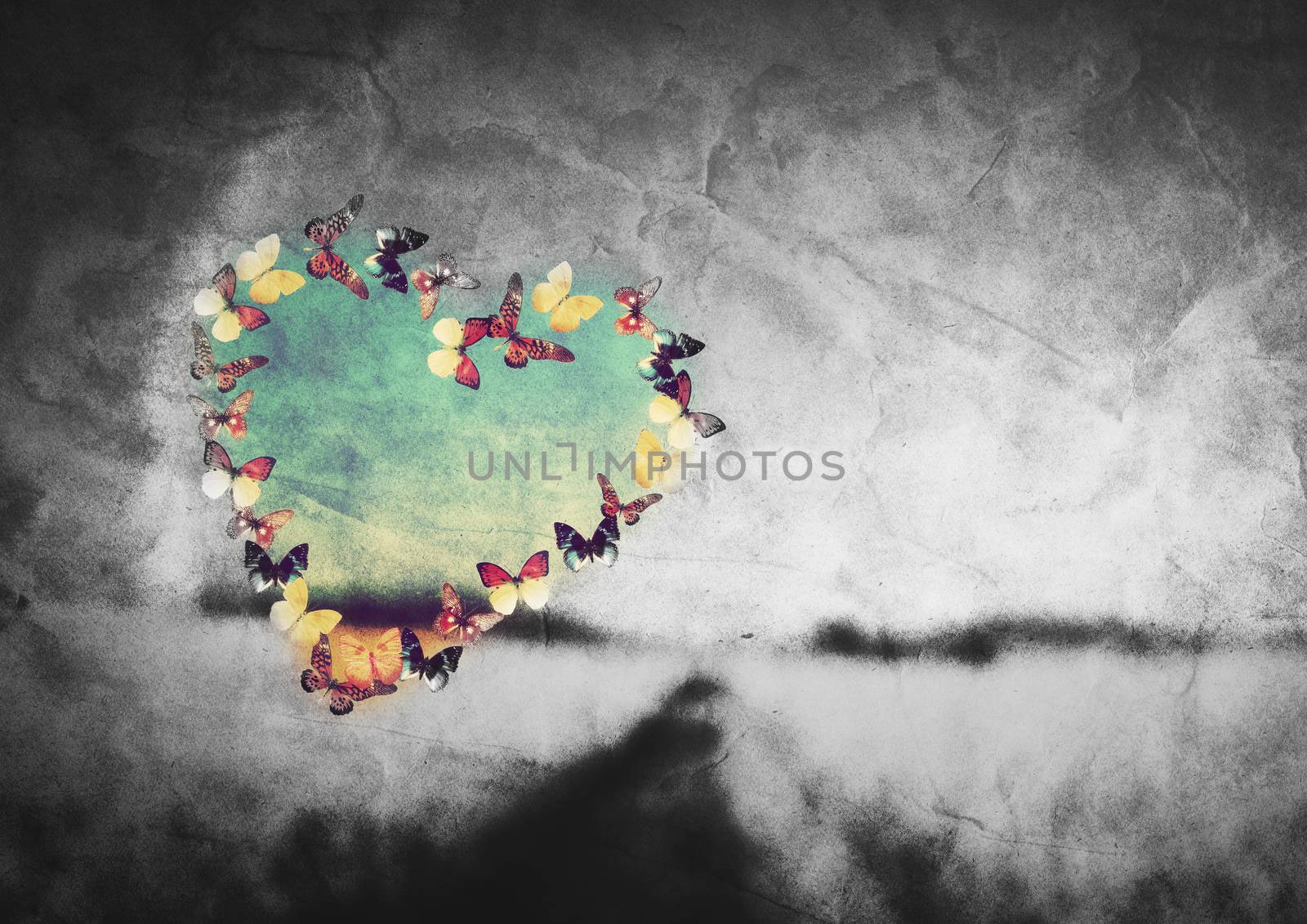 Heart shape made of colorful butterflies on black and white field vintage background. Love, hope concept.