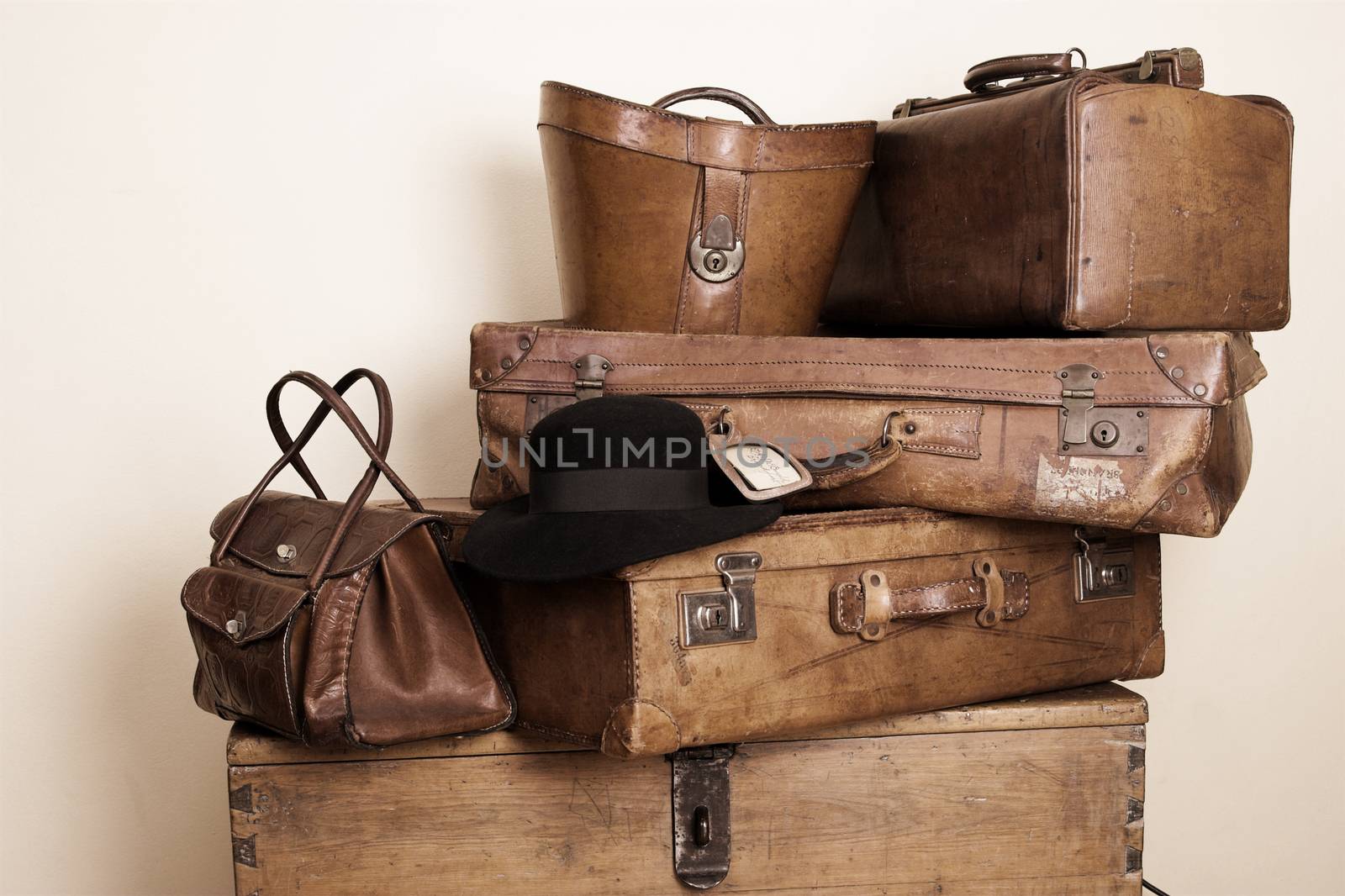 Collection of leather suitcases with a black suede hat
