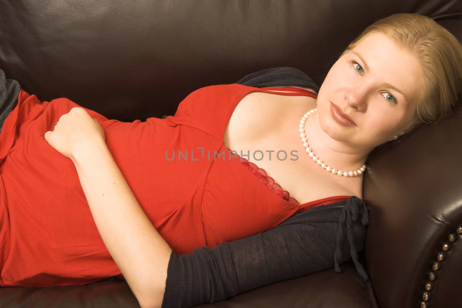 Beautiful young woman relaxing on a leather sofa