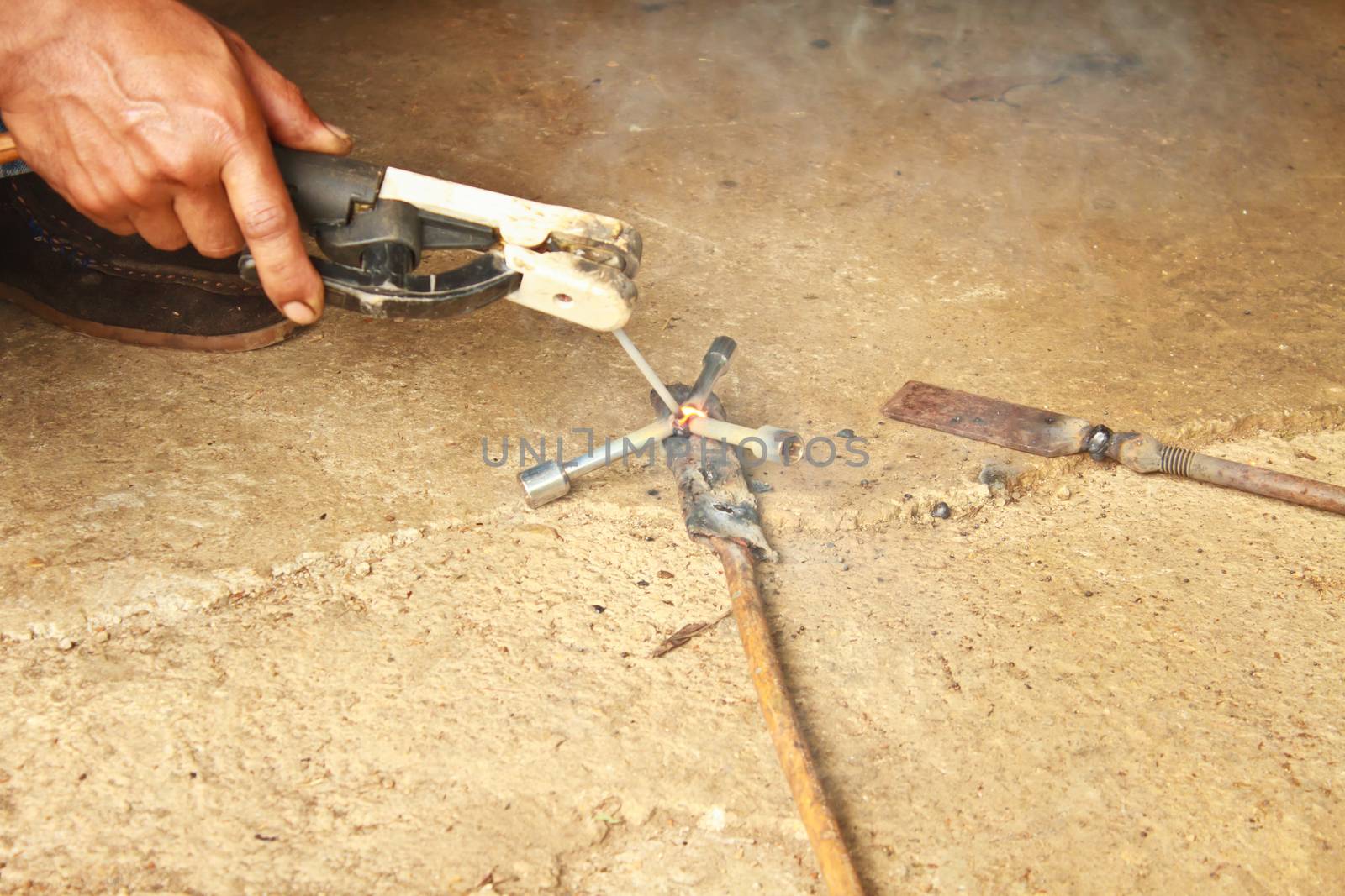 welder man welding steel on cement floor with spread spark