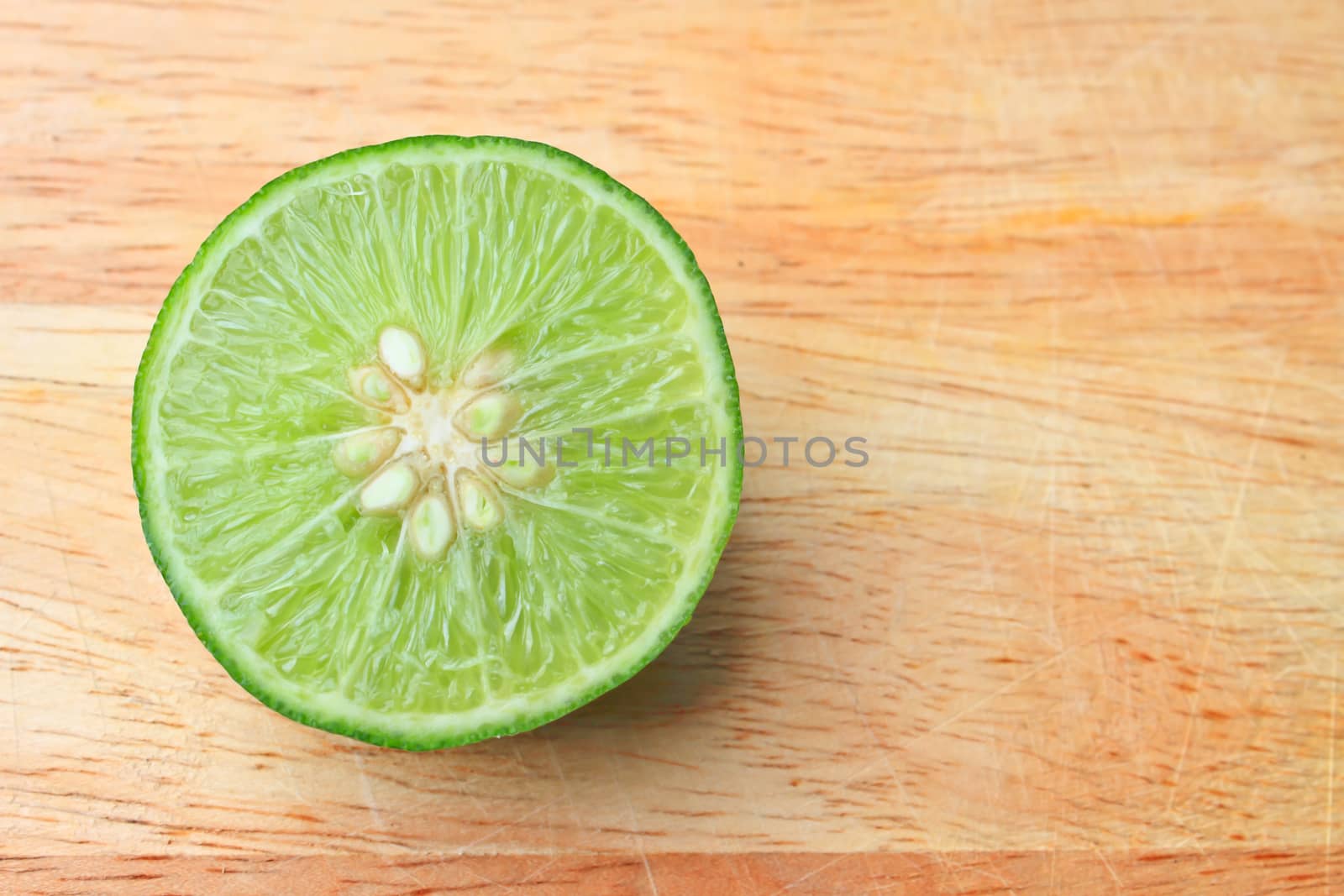 Fresh organic cut limes on wooden cutting board