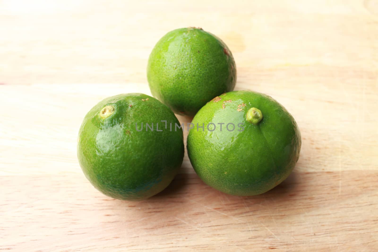 Fresh organic cut limes on wooden cutting board