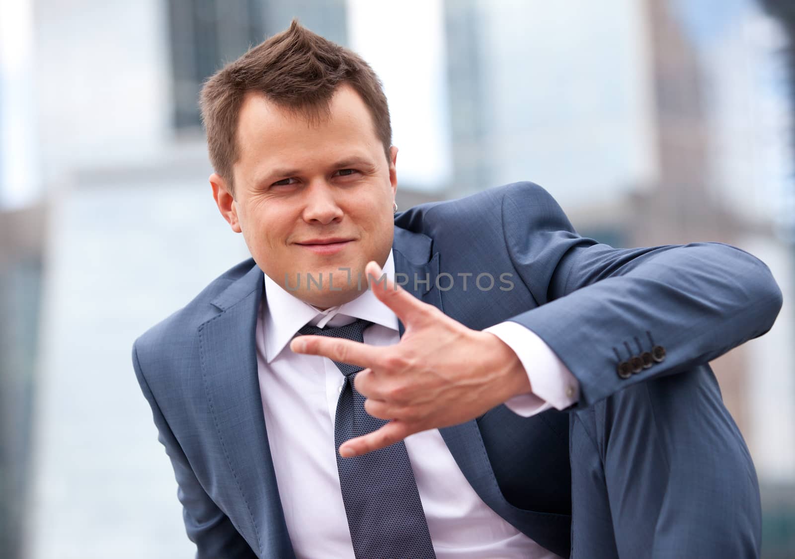 successful businessman smiling and  making a hand sign