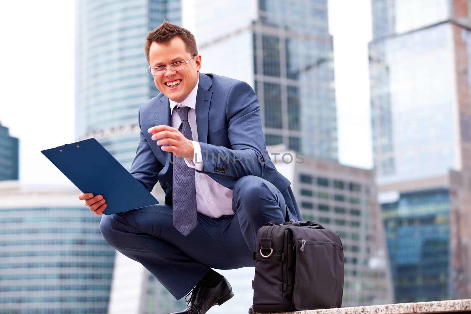 Successful businessman smiling on the background of office skyscrapers