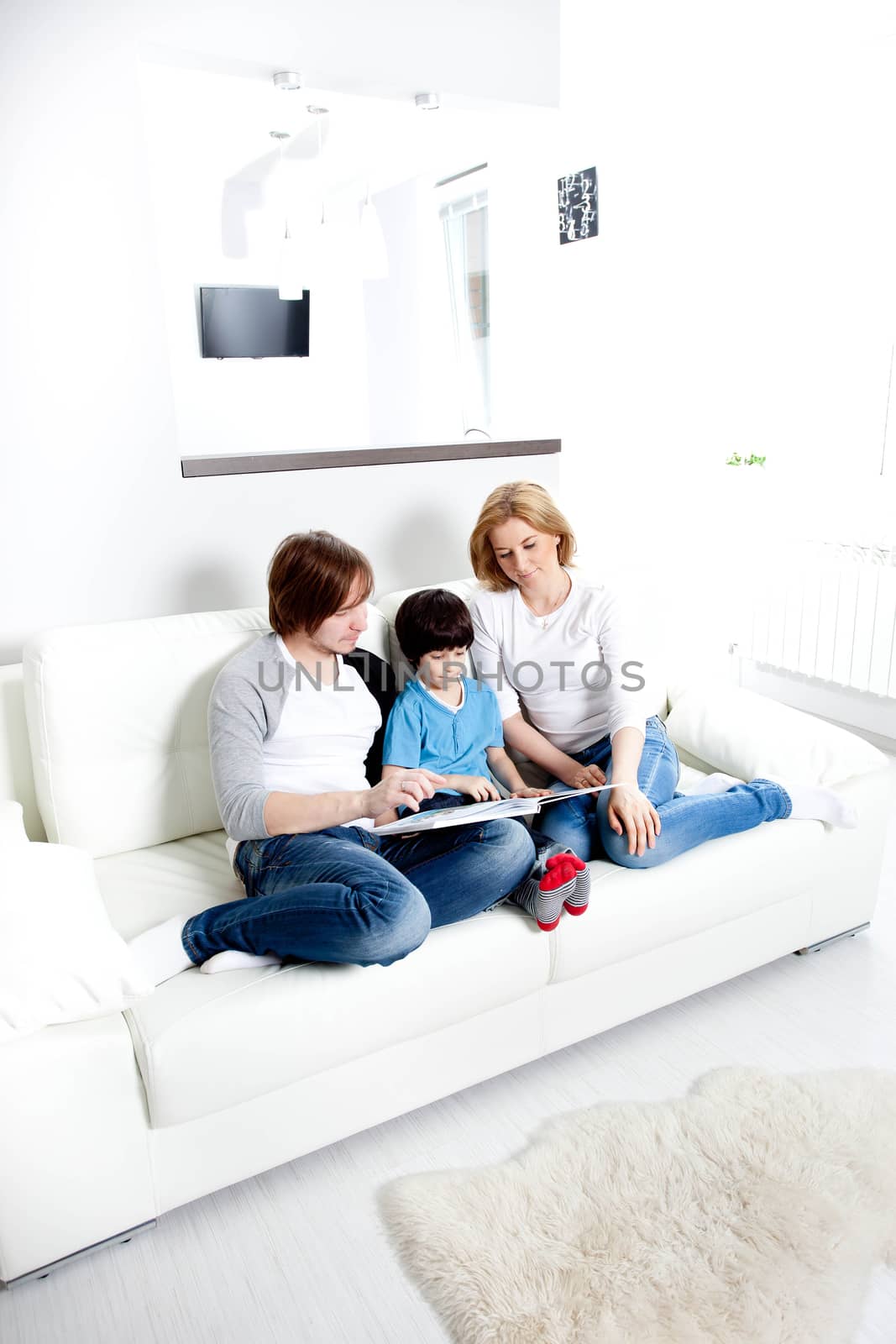 Portrait of friendly family reading book in home