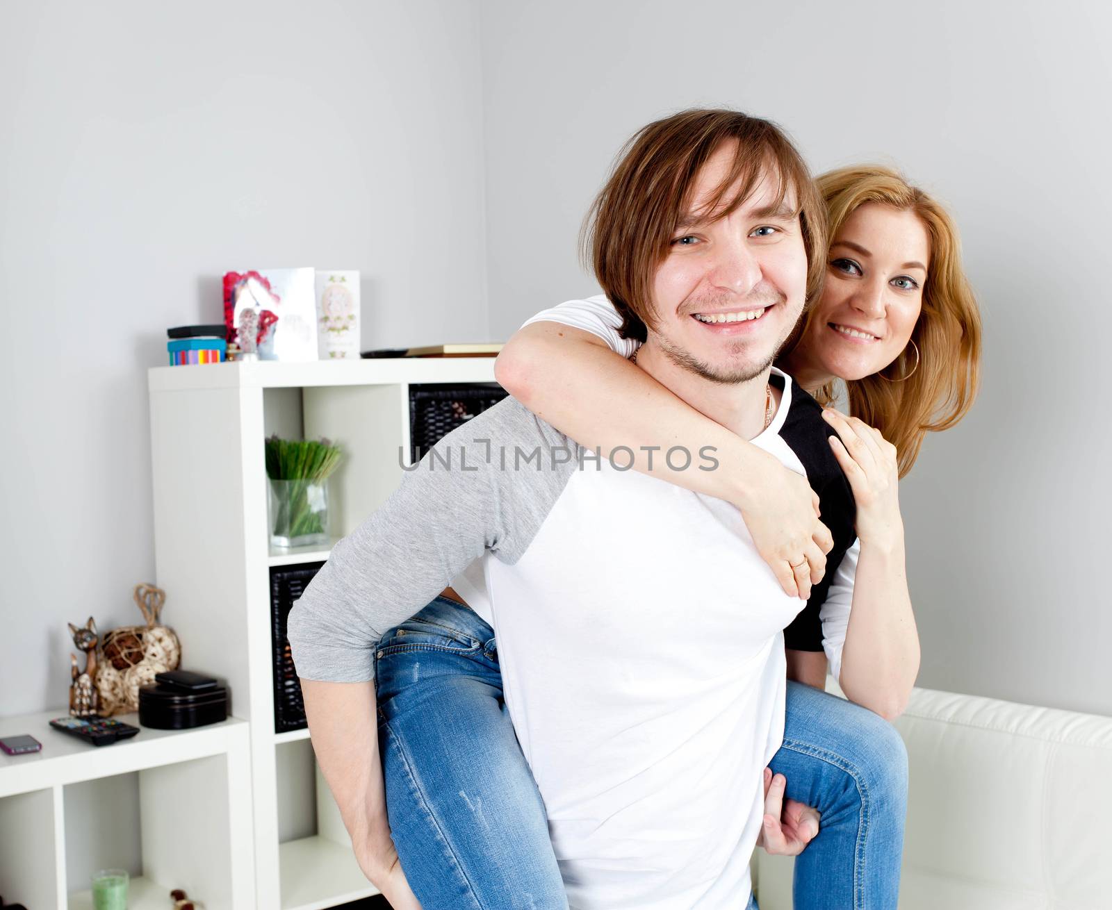 Man carrying girlfriend on his back in home