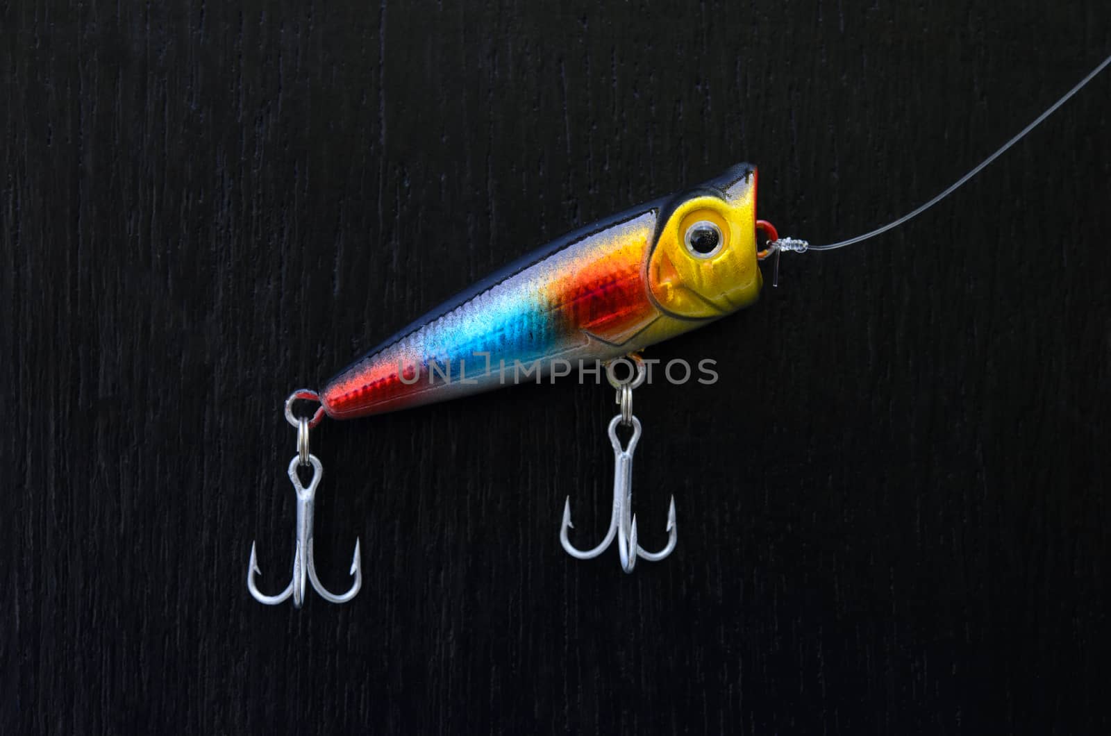close up of colorful fishing lure on a black board